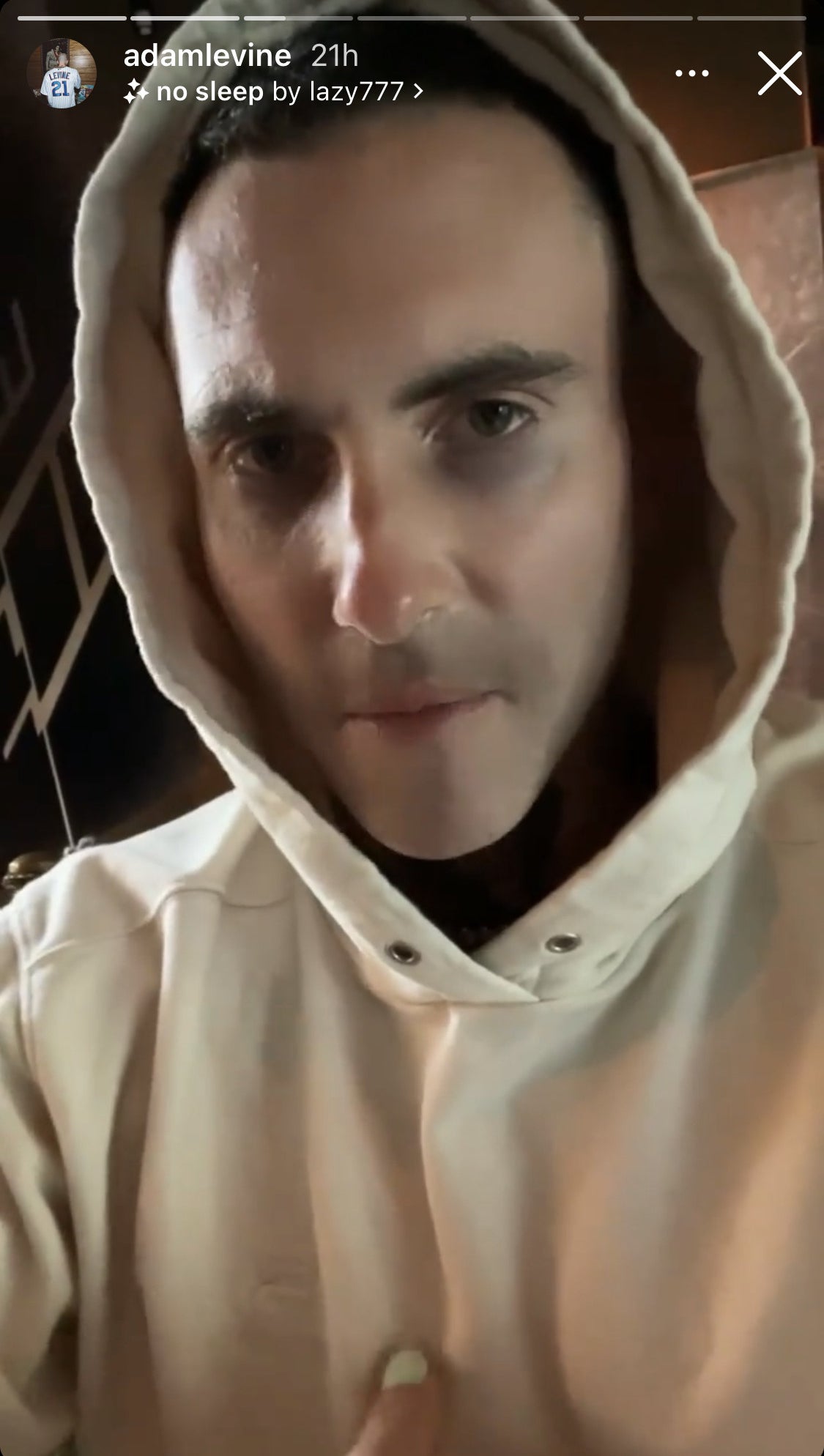 Screenshot of Adam as he addresses fans on his story, he wears a tan hoodie
