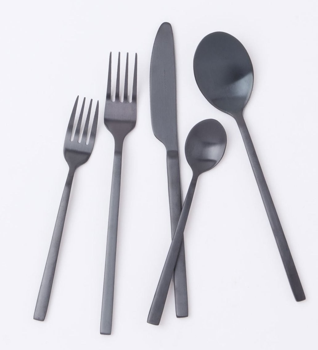 the flatware set in black, showing (from left to right) a salad fork, a dinner fork, a dinner knife, a small spoon, and a big spoon.