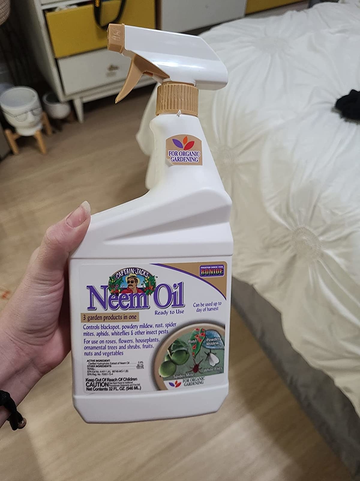 Reviewer holds up their bottle of neem oil
