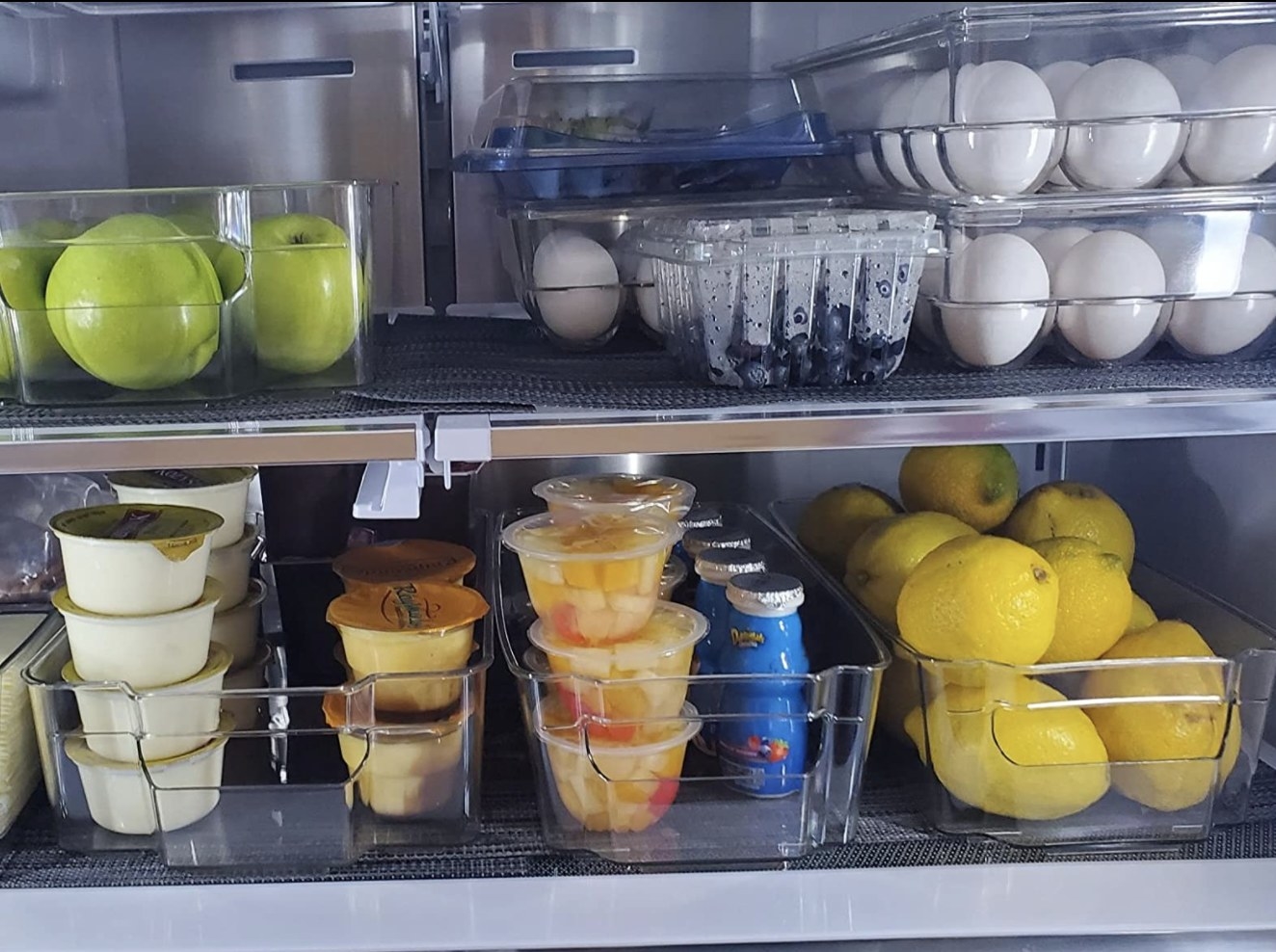 reviewer showing the storage bins in their fridge with fruit, eggs, etc.