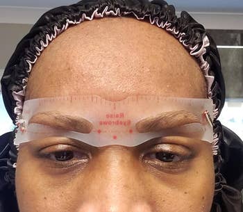 a reviewer wearing one of the included eyebrow stencils