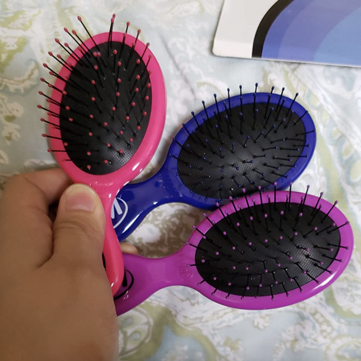 reviewer holding the three brushes