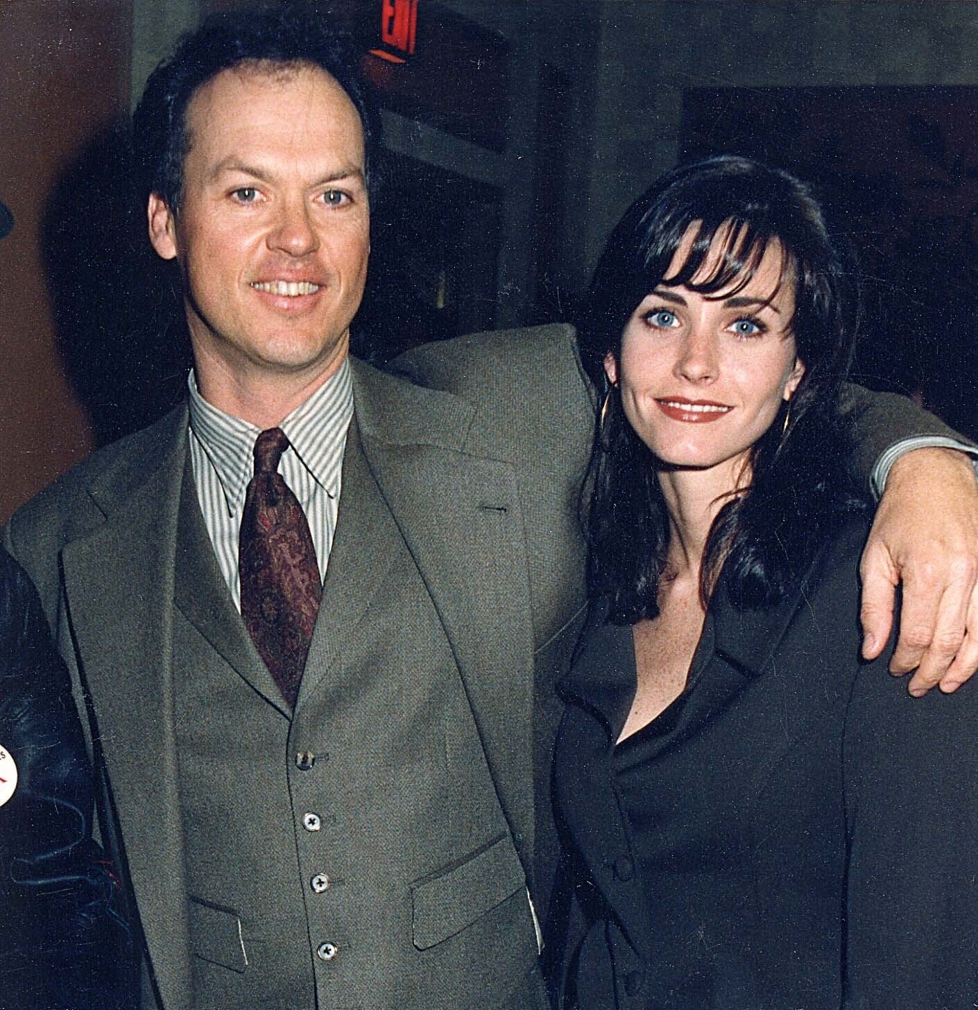 Photo of Courteney Cox and Michael Keaton smiling in suits