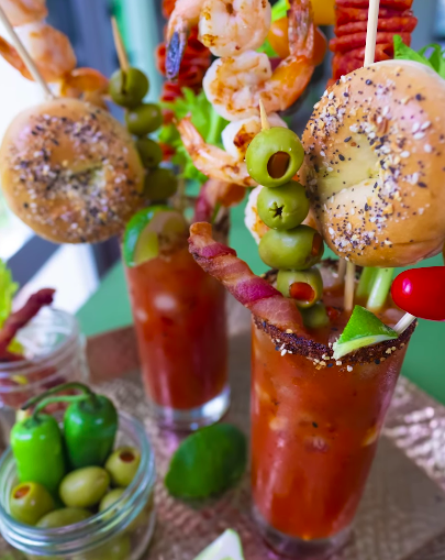 Bagels, olives, and bacon coming out of a Bloody Mary
