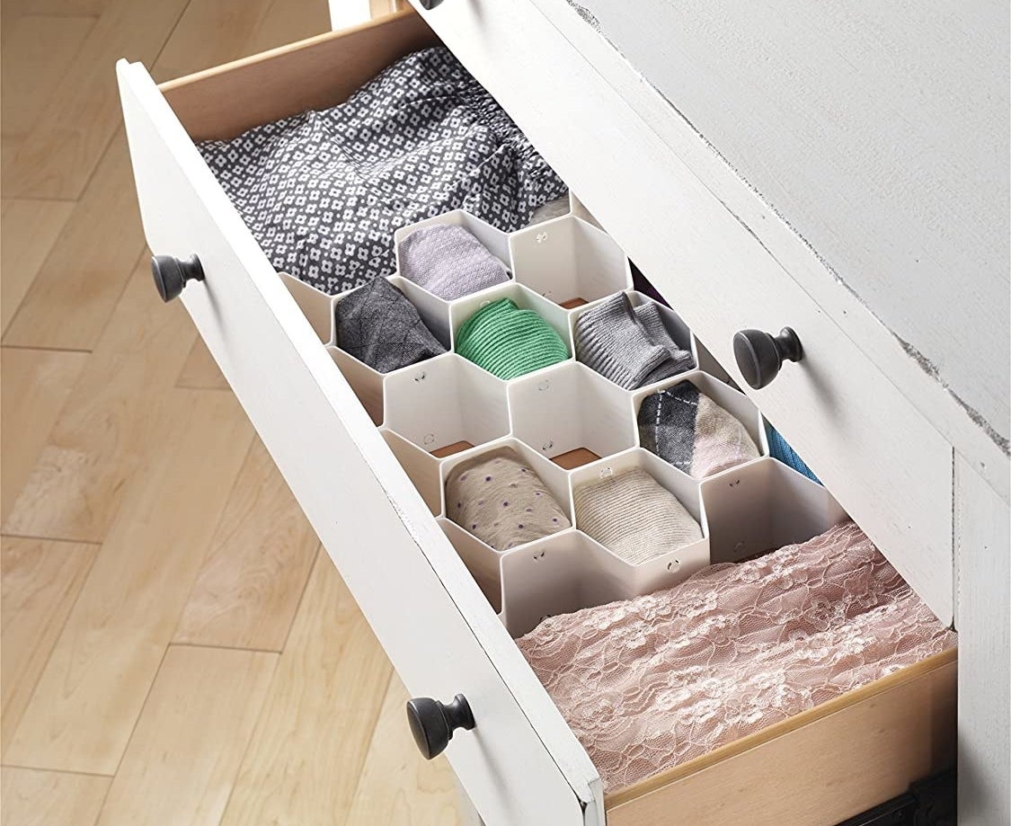 an open drawer with honeycomb-shaped organizers inside