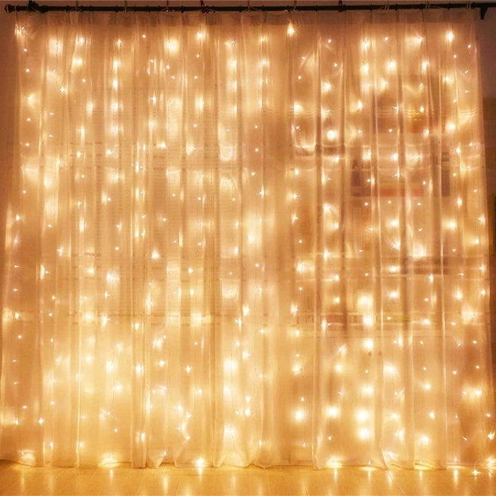 a window draped with the curtain fairy lights