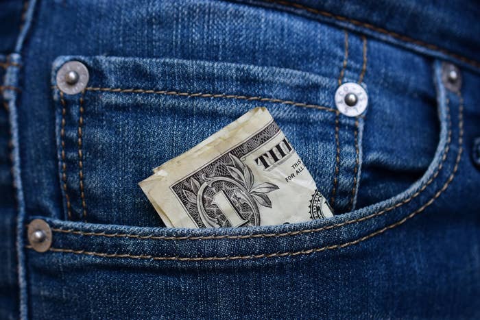 A one-dollar bill in a jeans pocket