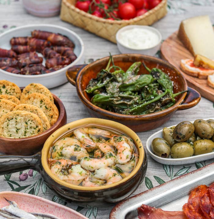 Variety of tapas in plates on a dining table.