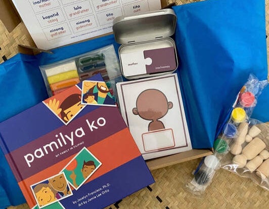 The Pamilya Ko kit with the book, paints, cards, and dolls all laid out