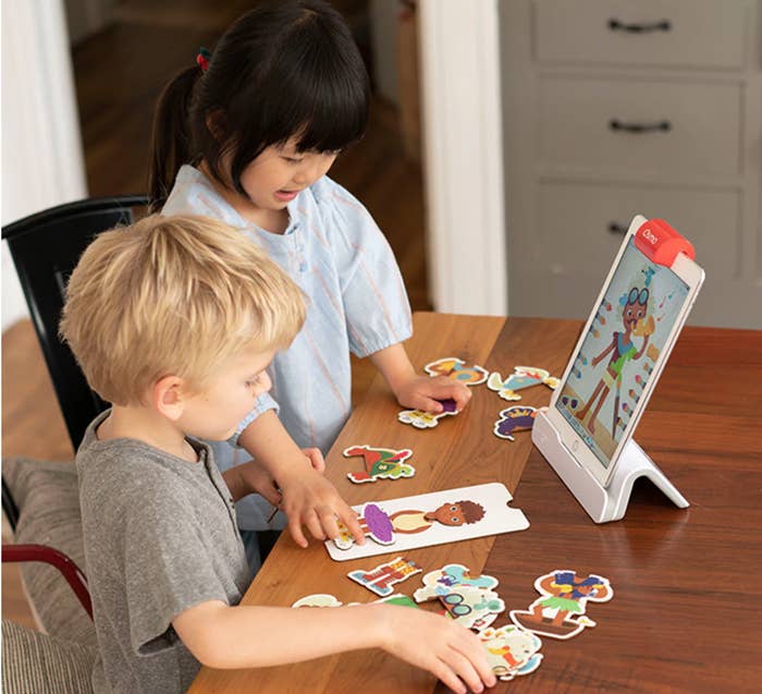 Two young children play Costume Party while looking at tablet