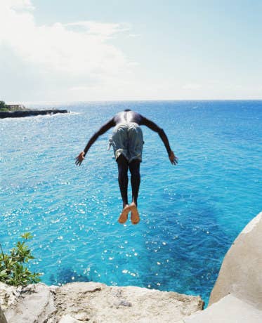 A man diving off a cliff in Jamaica.