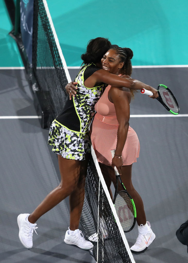 Serena and Venus hugging on the court. 