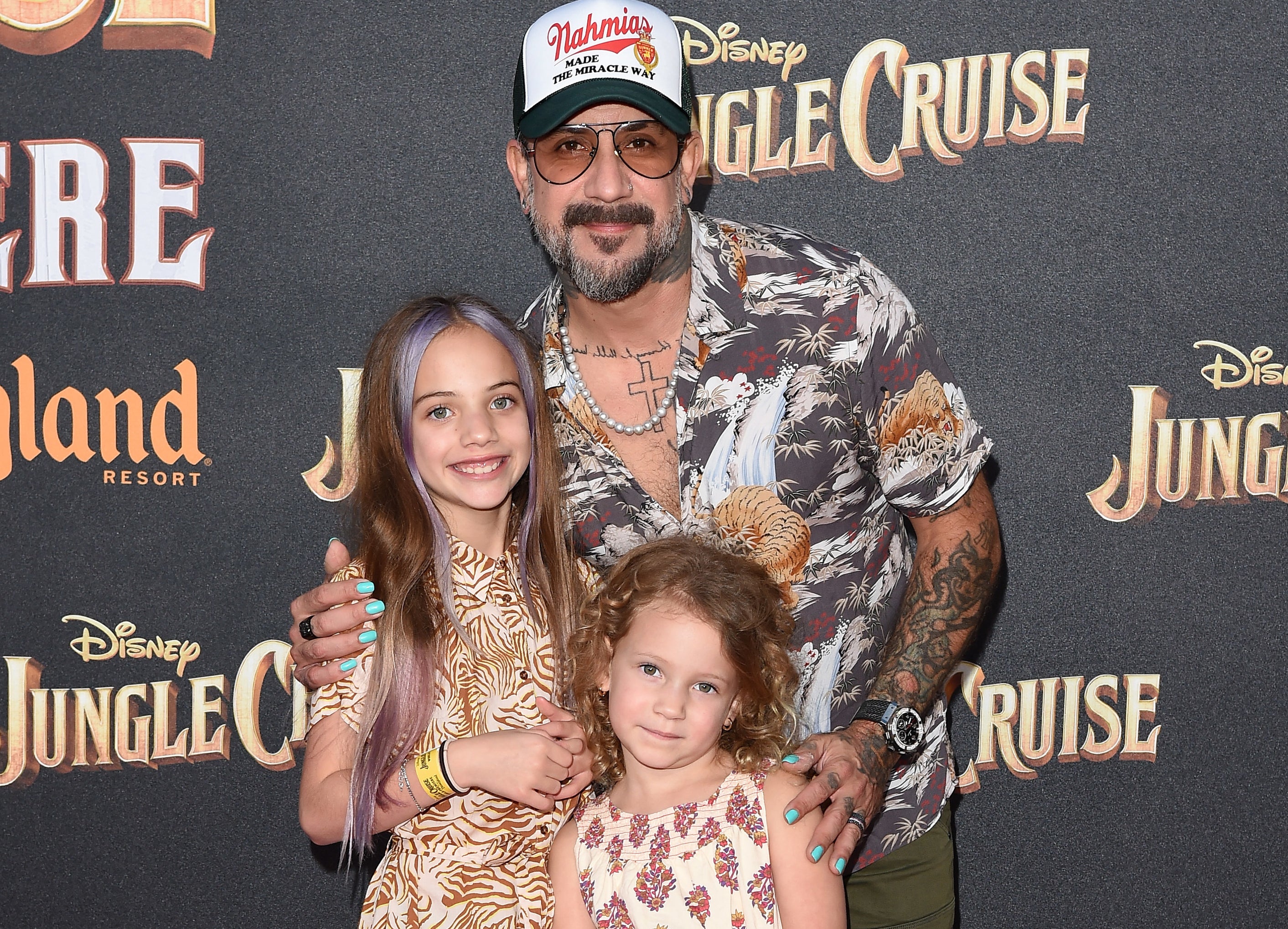 AJ stands with his daughters at an event
