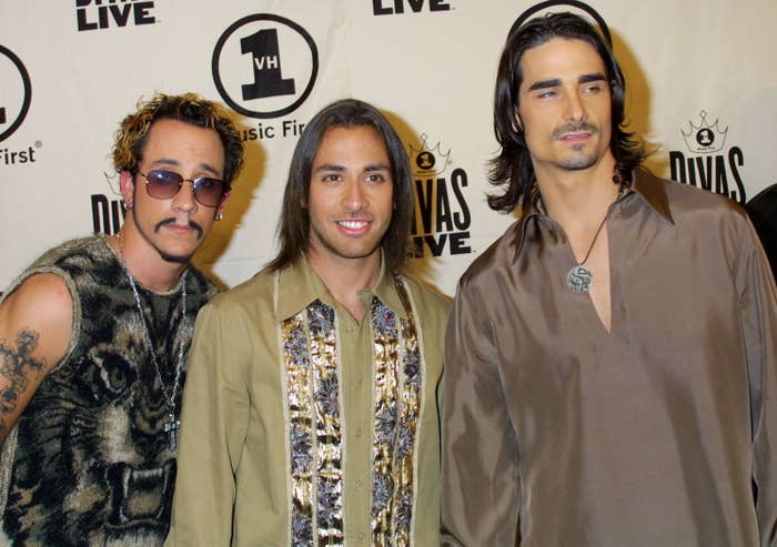 AJ has a mustache while standing with members of the Backstreet Boys many years ago