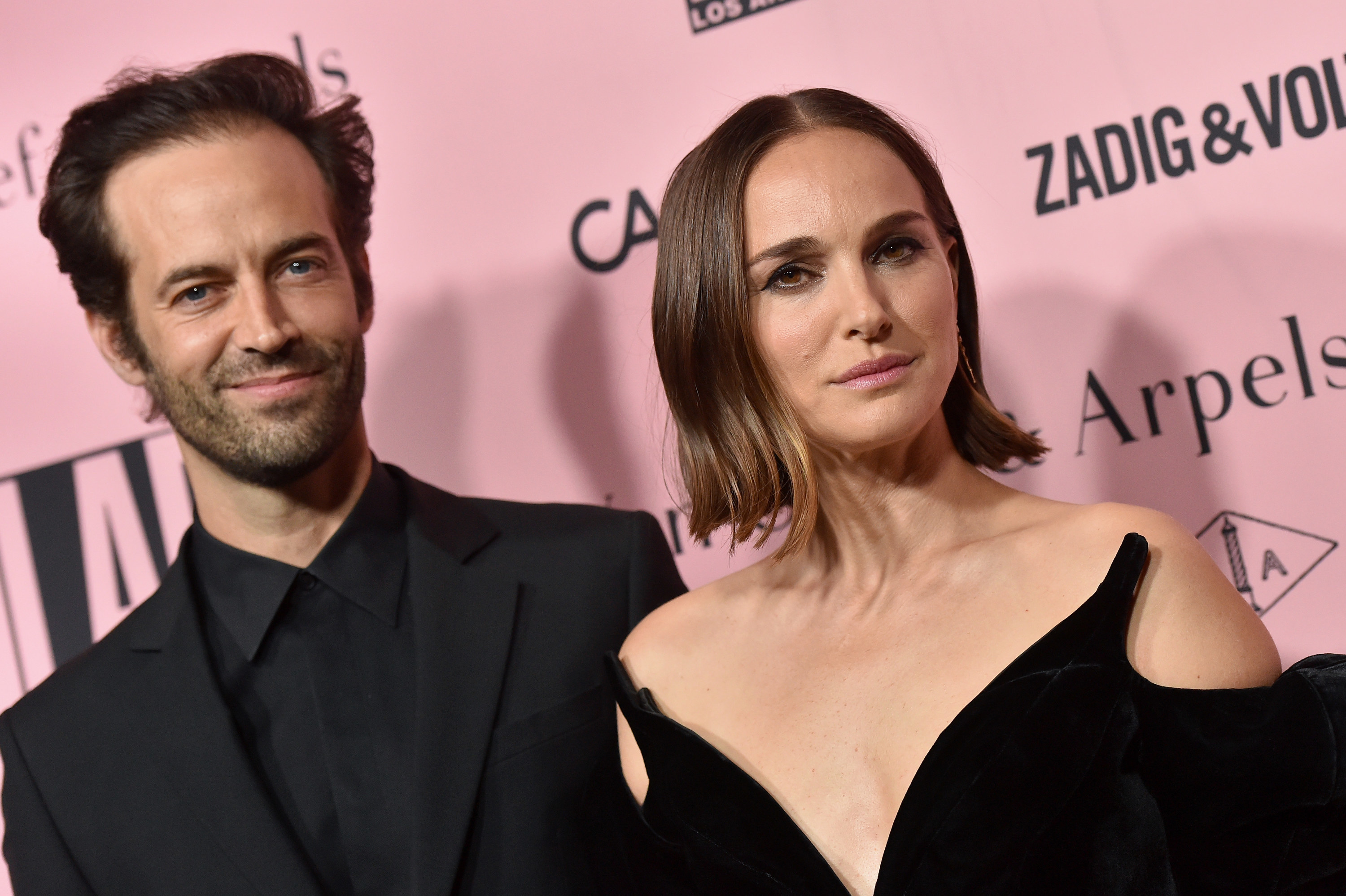 A man and a woman look into the camera.