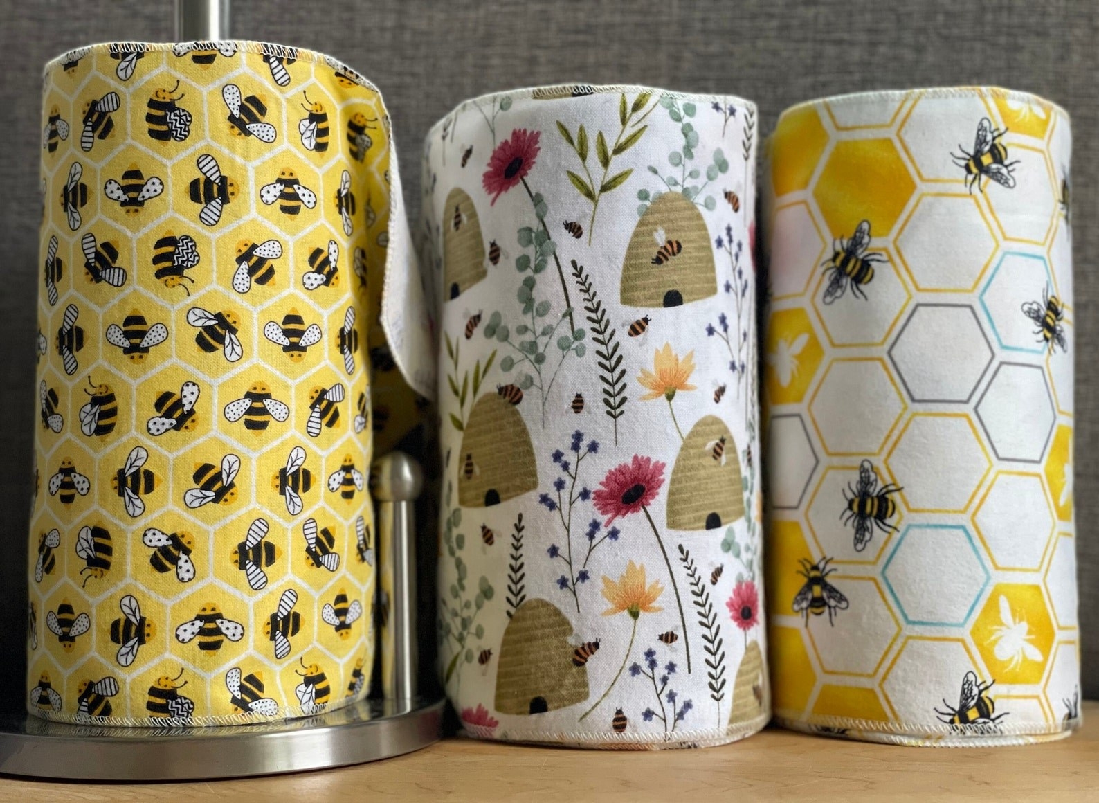 three rolls of paperless paper towels with bee imagery on them