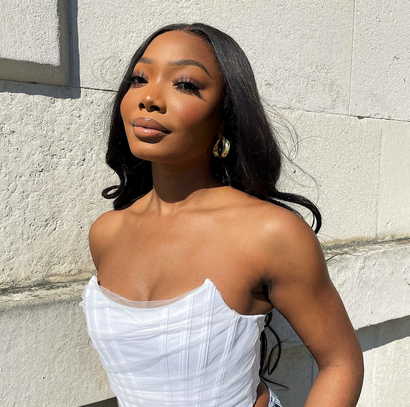  A Black woman in a white corset stares at the camera.