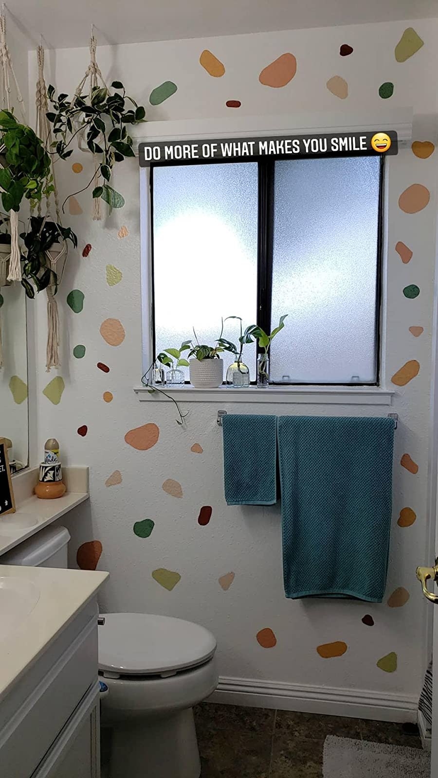 reviewer image of a wall in a bathroom covered in peel and stick colored shapes