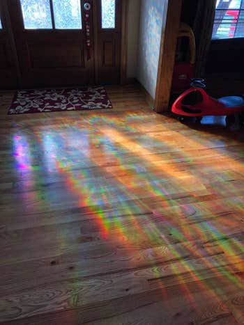 Light shining through a window with the film and projecting rainbow patterns on a floor