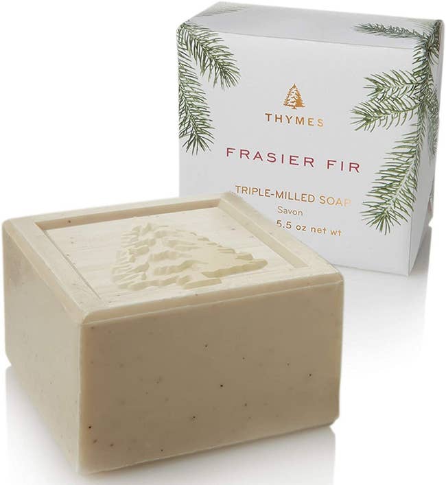 A bar of soap imprinted with a tree design, next to a bar of the soap in its packaging