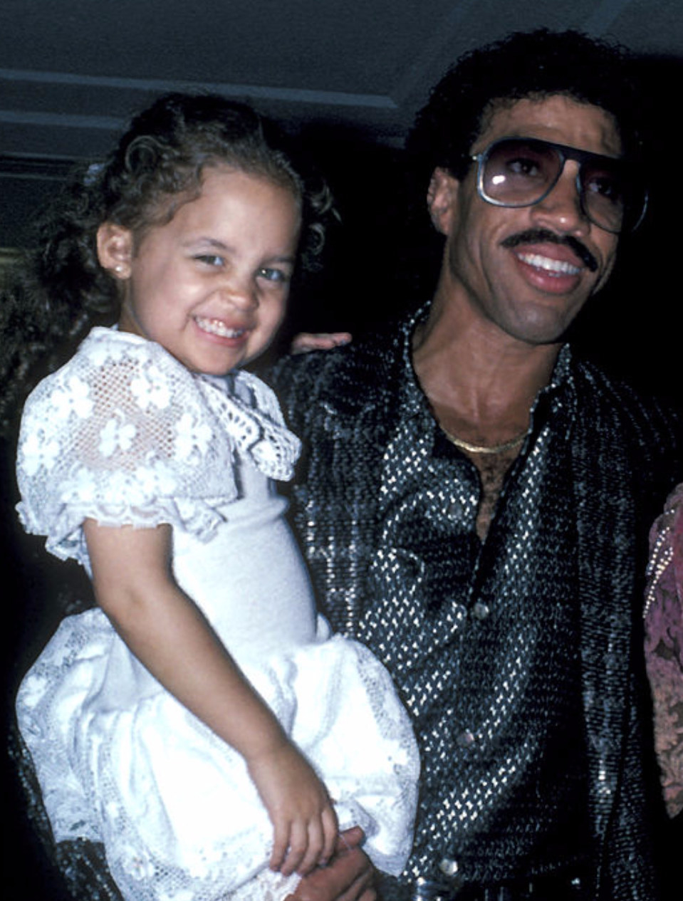 Lionel Richie holding a young Nicole Richie at an event in 1985