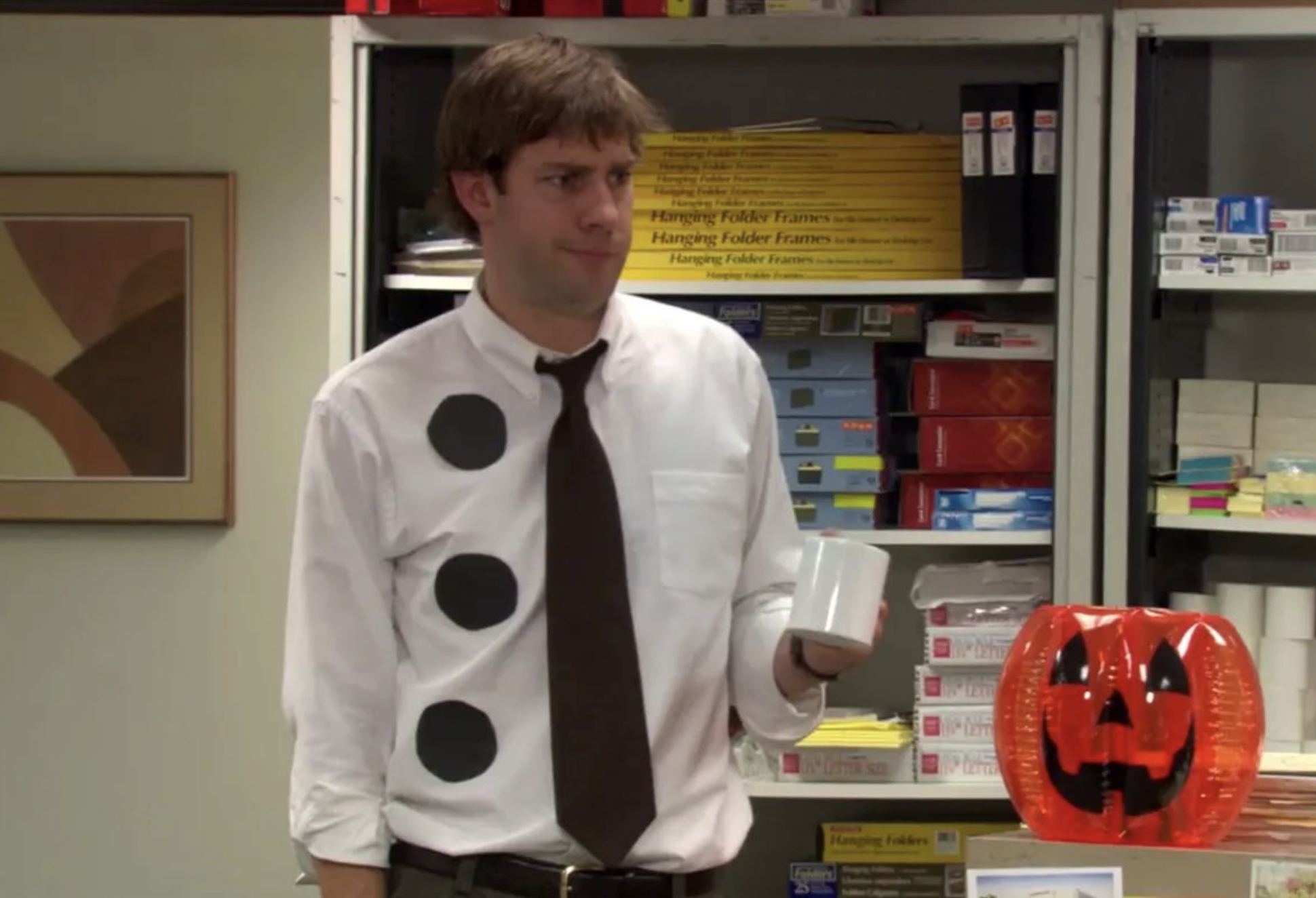 Jim wears three black circles on his white shirt to look like a piece of paper
