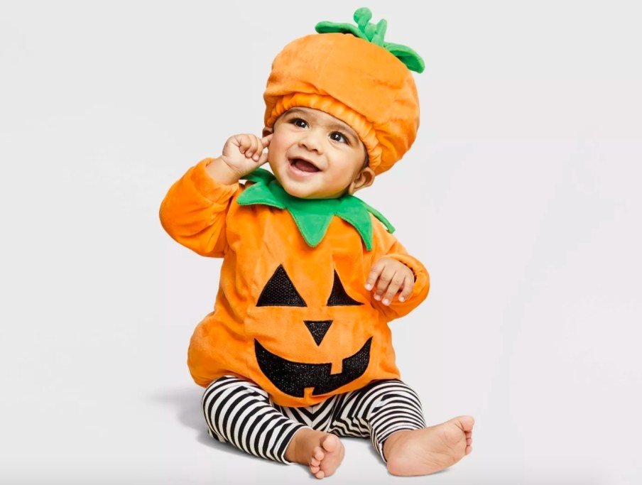 Baby dressed in pumpkin costume.