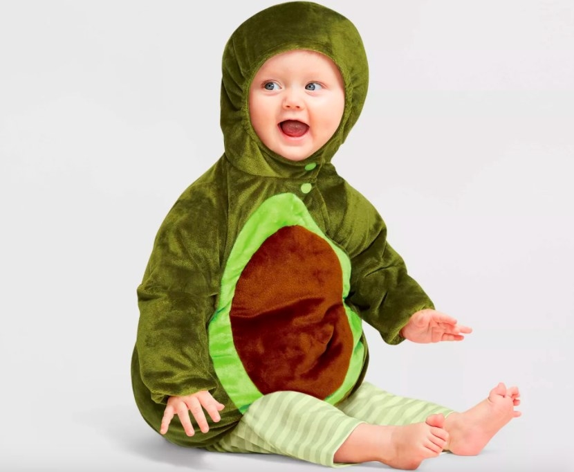 Baby dressed in avocado costume with striped green leggings.