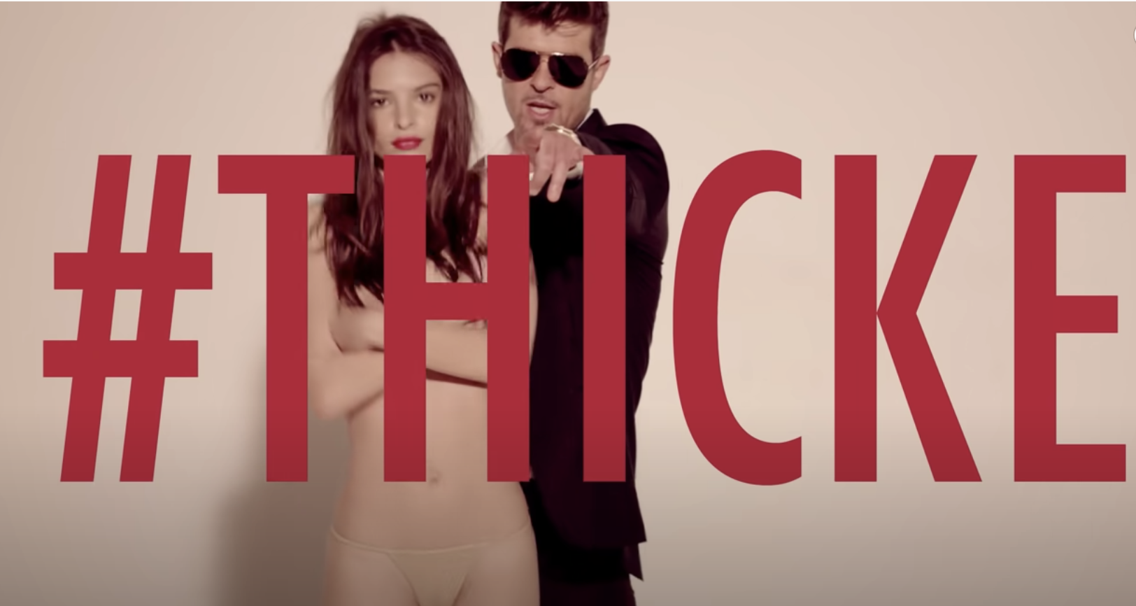 Emily standing with her arms covering her bare breasts as Robin sings behind her with #Thicke written across the screen in a still from the music video