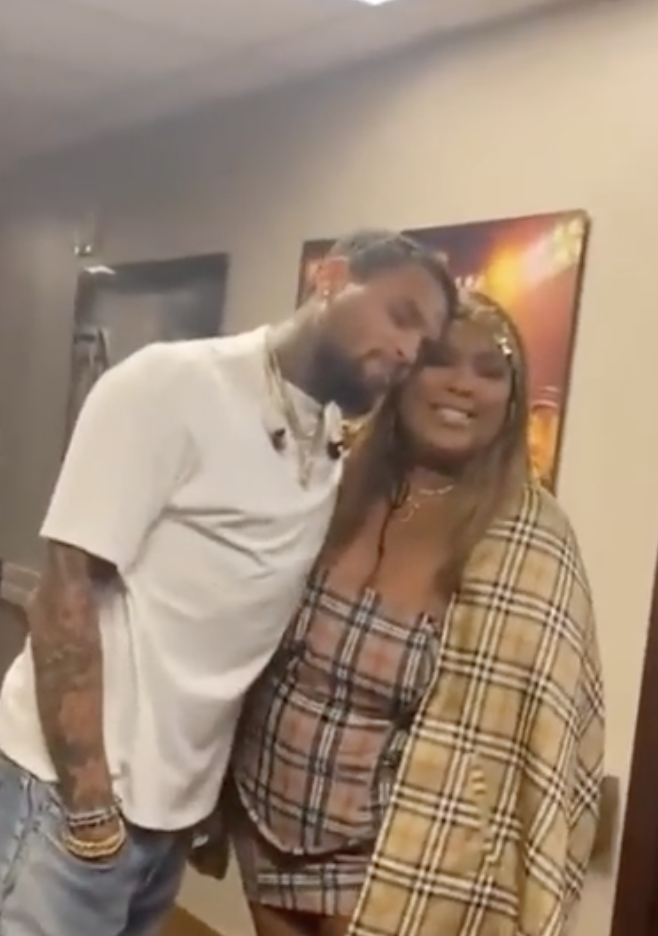 Chris and Lizzo standing together with faces touching