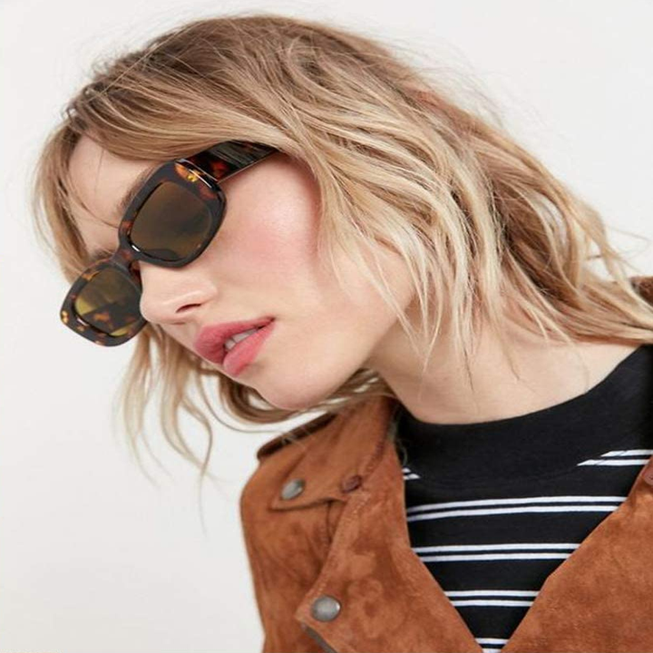A model wearing a pair of boxy sunglasses