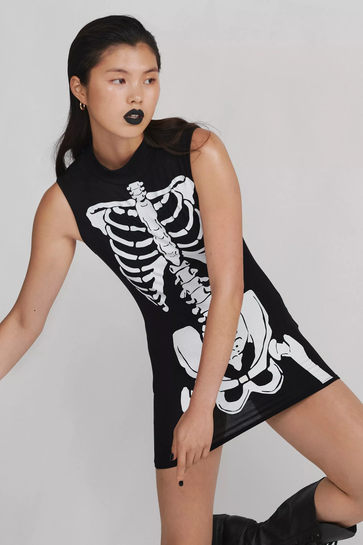 A person wearing a short bodycon dress with a skeleton printed on the front
