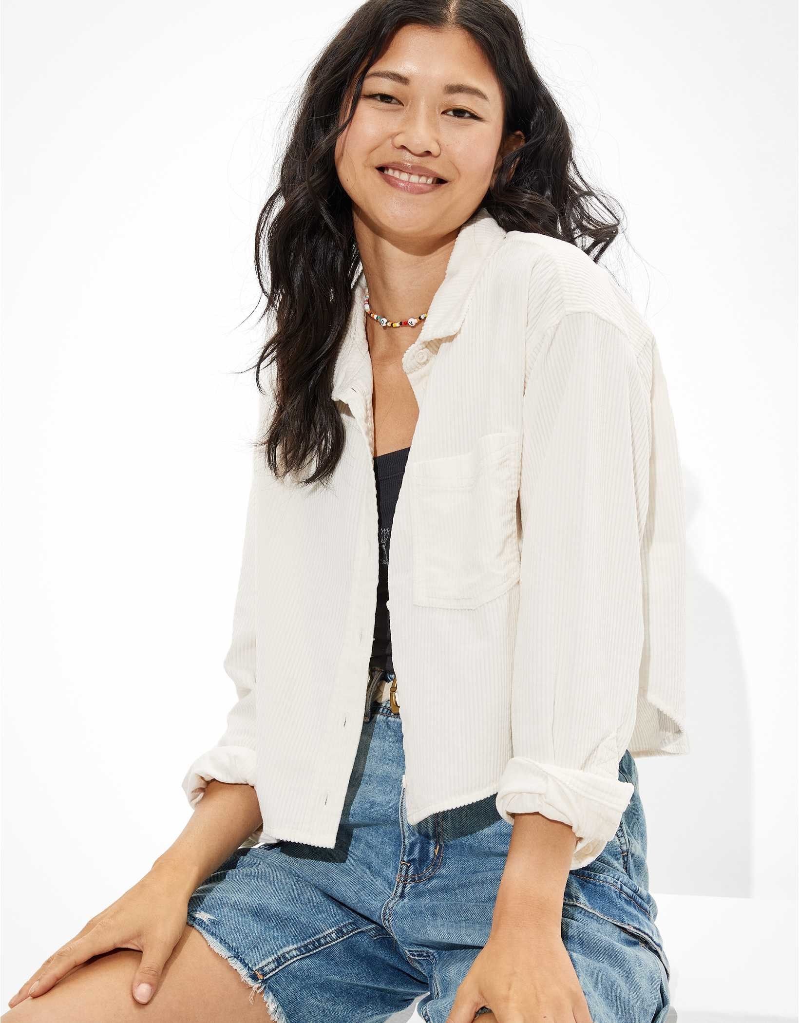 A model wearing a white cropped corduroy button up