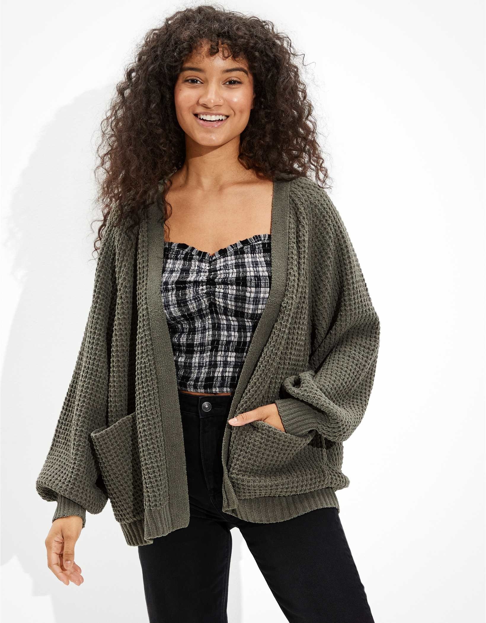 A model wearing an olive oversized chenille cardigan