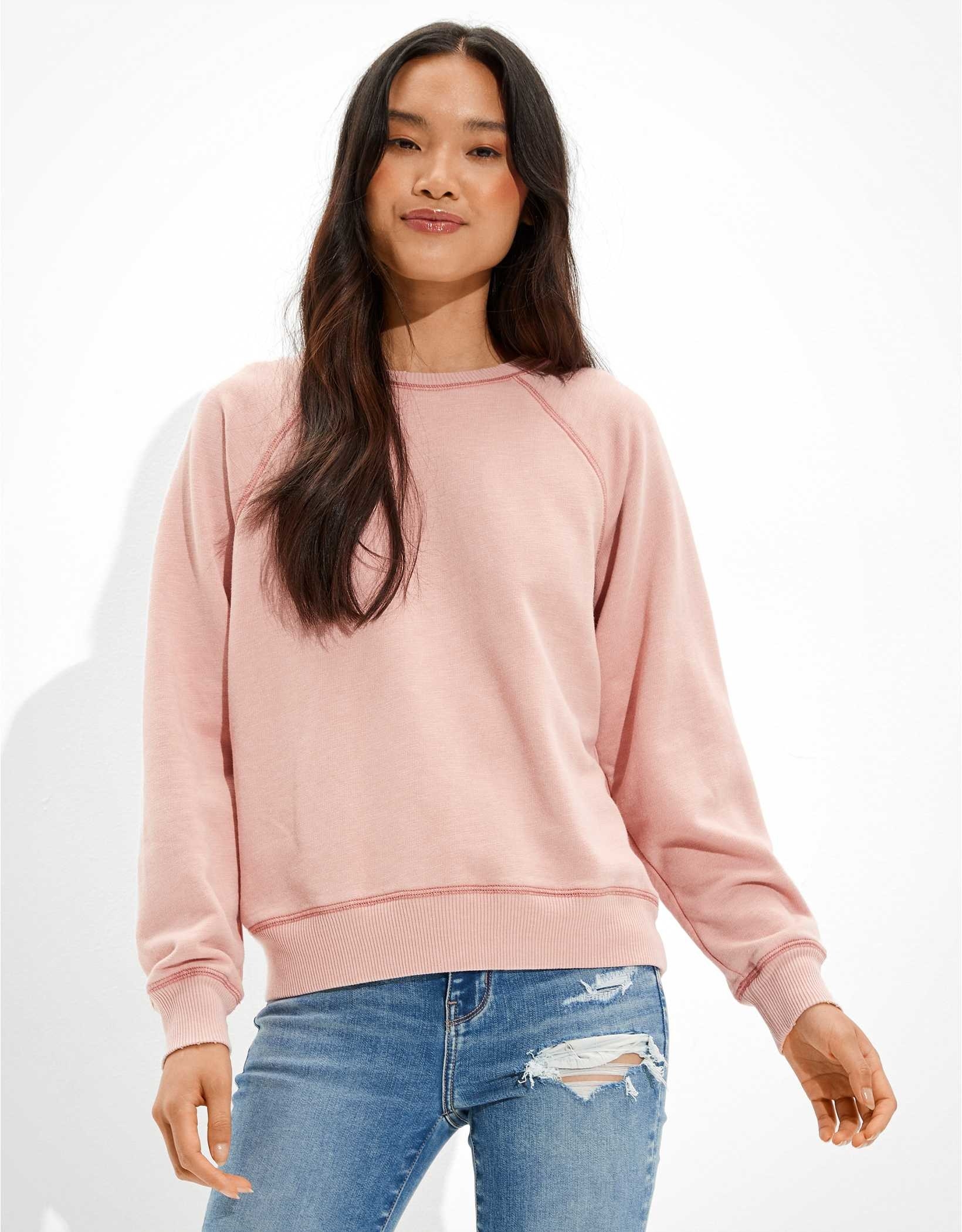A model wearing a rose crew neck sweatshirt