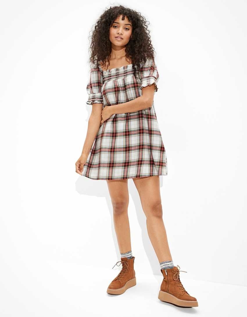 A model wearing a plaid smocked puff sleeve baby doll dress