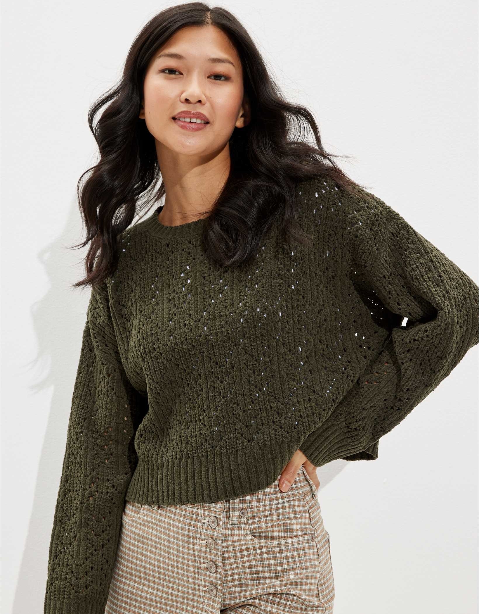 A model wearing an olive pointelle crew neck sweater