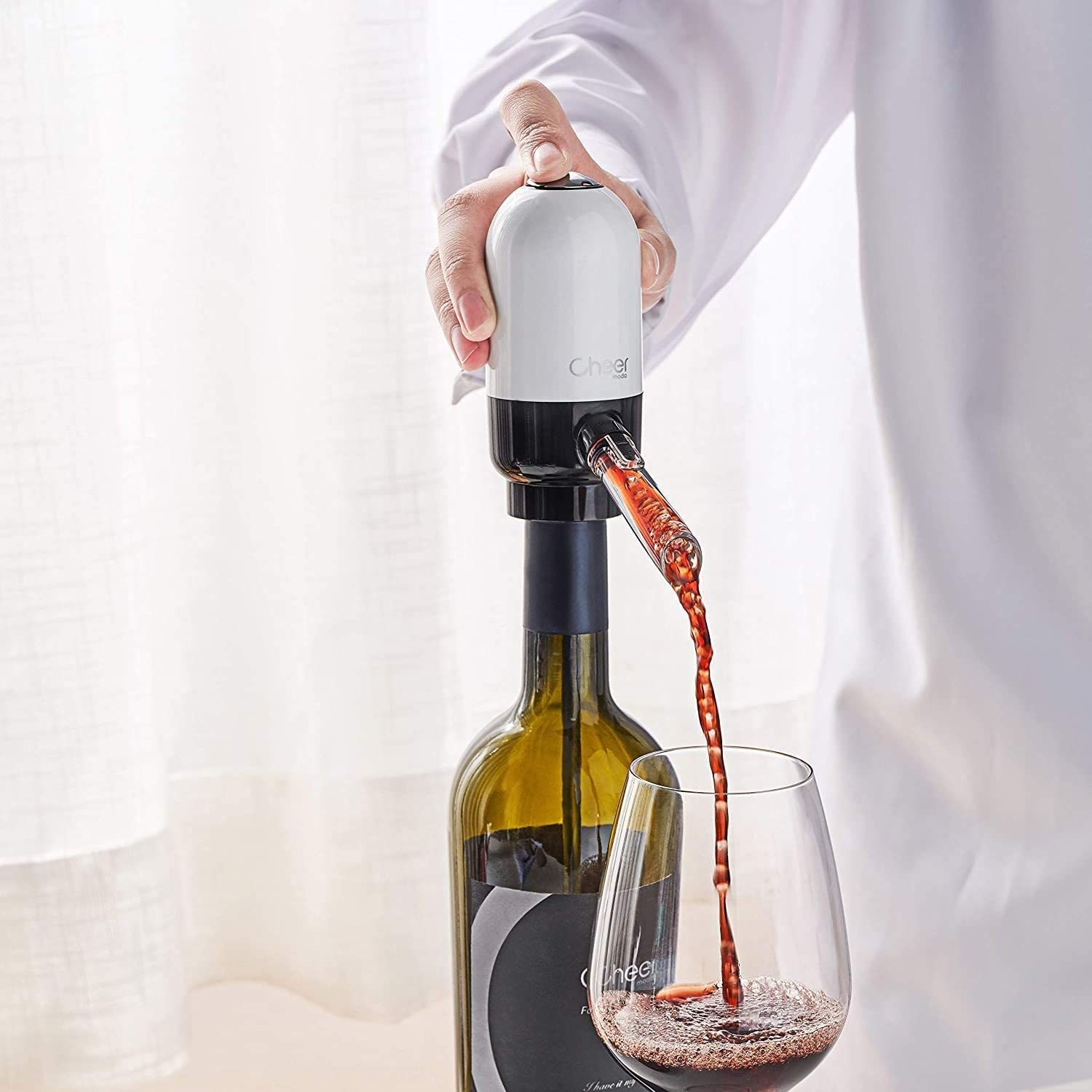 A person pouring wine into a glass from the aerator spout