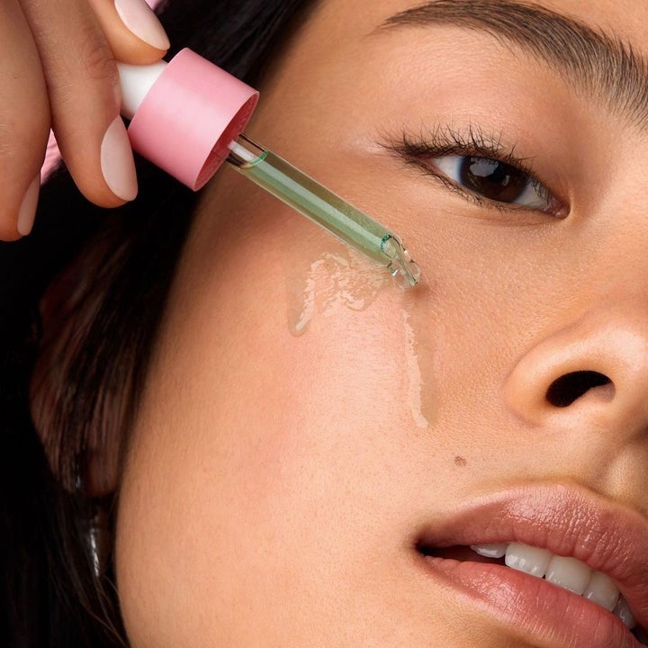 model using a dropper bottle to apply the green liquid