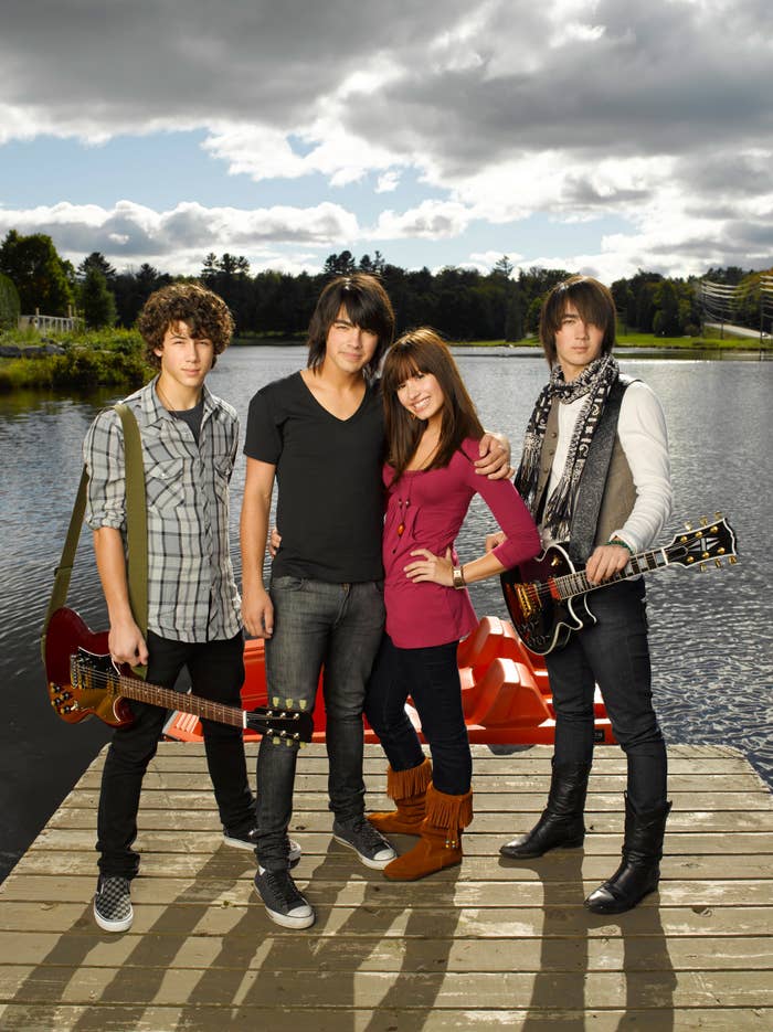 Costars of Camp Rock standing on a pier, with Joe Jonas and Demi Lovato embracing