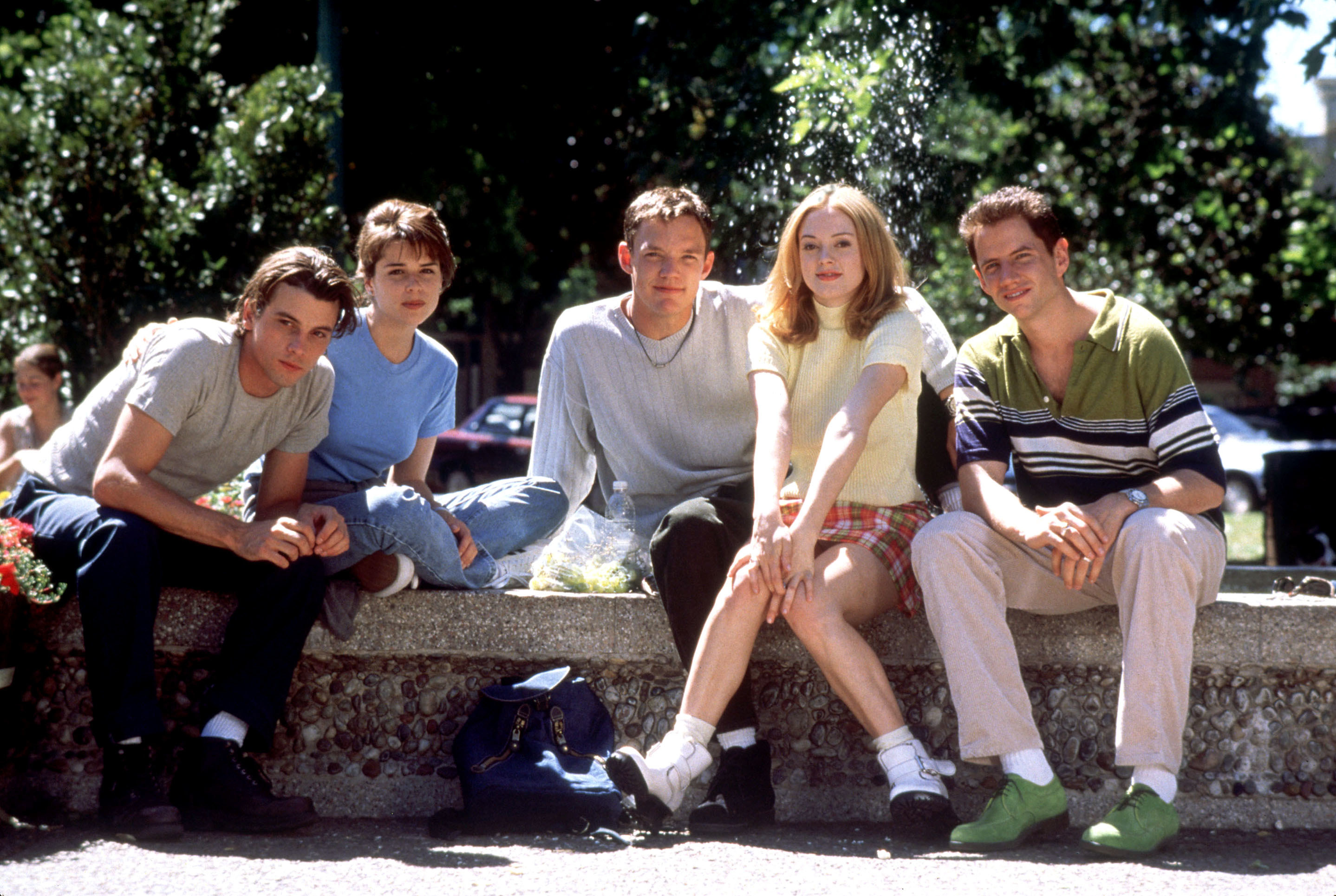 The cast of Scream sits by a fountain