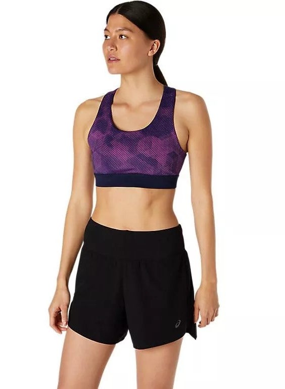 A model wearing the purple and black sports bra