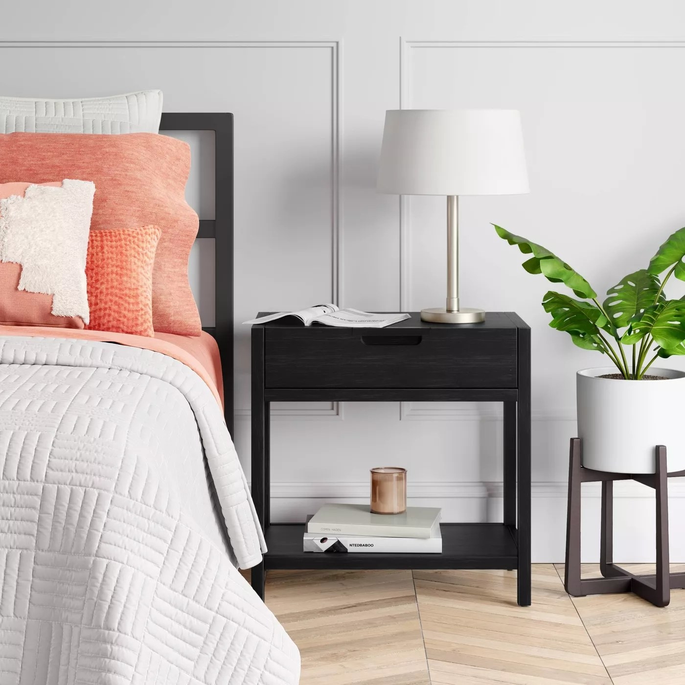 The nightstand with a drawer and open shelf underneath in a bedroom