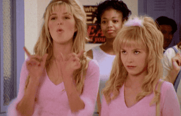 Kate from Lizzie McGuire signaling a whatever sign with her hands and rolling her eyes