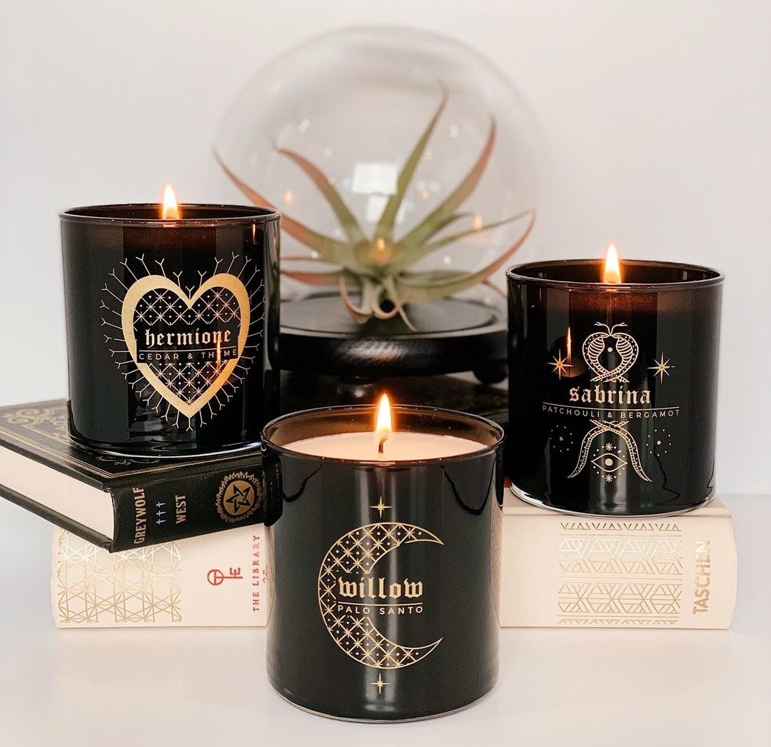 hermione, willow, and sabrina candles sitting on books