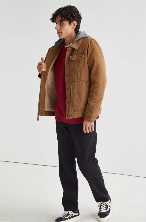 Model wearing tan jacket with black pants and red shirt