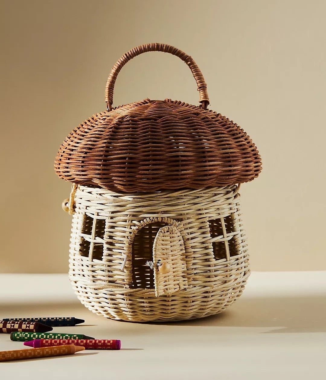 wicker basket in the shape of a mushroom, with a hinged front door and windows on the front