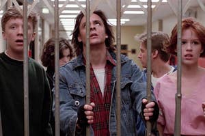 Brian, Allison, Bender, Andrew, and Claire from The Breakfast Club standing in a school hallway blocked off by bars