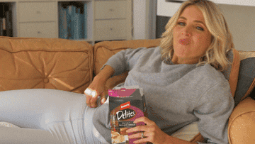 GIF of a woman relaxing on the couch in comfortable clothes