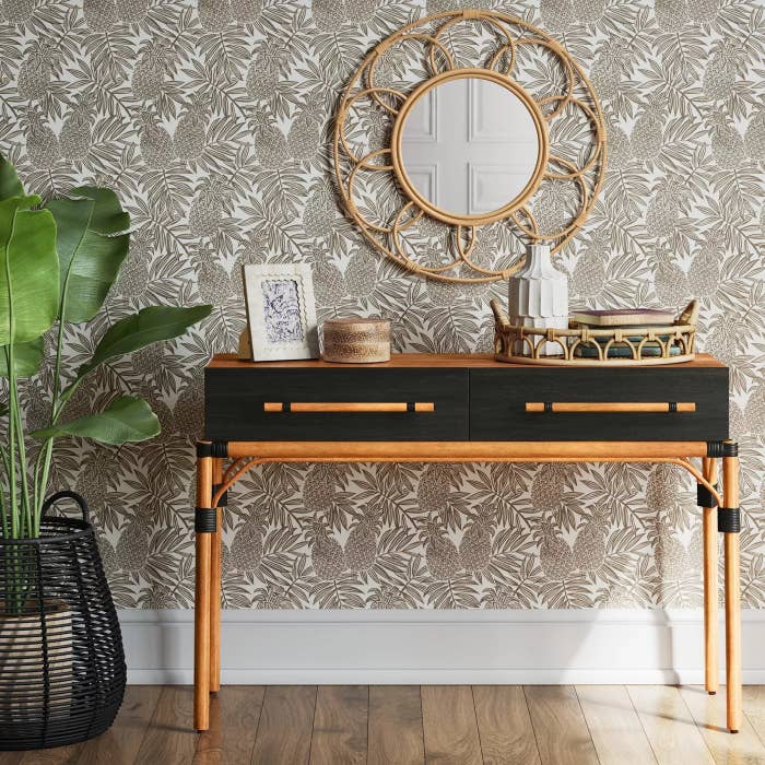The black console table with wooden legs and two drawers